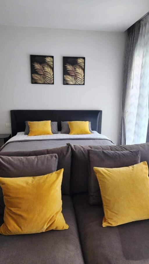 Modern bedroom with grey bed and yellow accent pillows