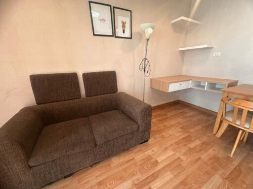 Cozy living room with brown couch and wall-mounted desk