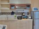 Modern kitchen with stainless steel appliances and mosaic backsplash