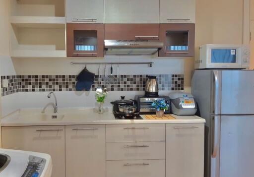 Modern kitchen with stainless steel appliances and mosaic backsplash