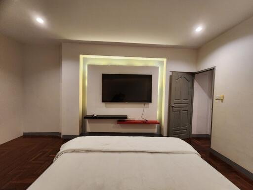 Modern bedroom with a wall-mounted TV and a door