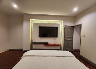 Bedroom with mounted flat-screen TV and modern lighting