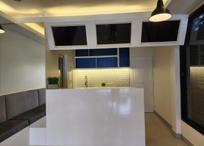Modern kitchen with white and blue cabinetry, white subway tile backsplash, and built-in screens