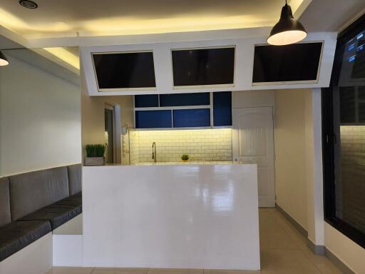 Modern kitchen with white and blue cabinetry, white subway tile backsplash, and built-in screens