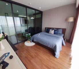 Modern bedroom with glass partition and wooden flooring