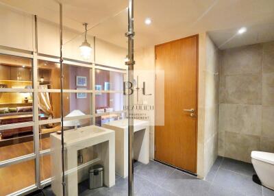 Modern bathroom with glass partition and wooden door