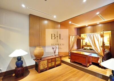 Luxurious and spacious bedroom with wooden flooring, elegant furniture, and ambient lighting