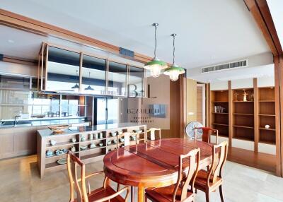 Spacious dining room with wooden table and chairs, modern lighting, and built-in shelves.