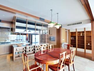 Spacious dining room with wooden table and chairs, modern lighting, and built-in shelves.