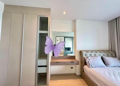 Modern bedroom with a large mirror, built-in wardrobe, and comfortable bed