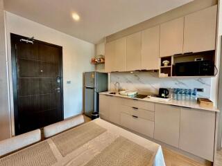 Modern kitchen with light beige cabinets and dining area