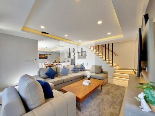 spacious living room with modern furniture and staircase