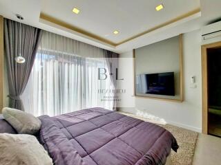 Modern bedroom with large window and mounted TV