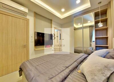 Modern bedroom with built-in wardrobe and wall-mounted TV