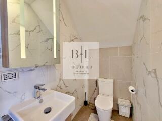 Modern bathroom with a sink, mirror, and toilet