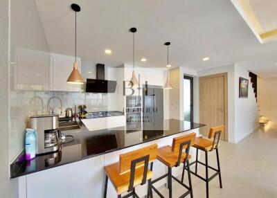 Modern kitchen with bar stools and pendant lights