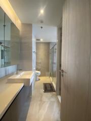 Modern bathroom with a large mirror, double sink, large window, and shower area.