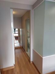 Modern hallway with wooden flooring, leading to a distant room