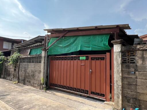 Front view of a single-story house with a gated entrance