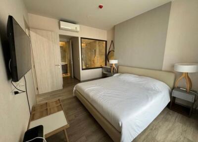 Modern bedroom with double bed, wall-mounted TV, air conditioning, and ensuite bathroom