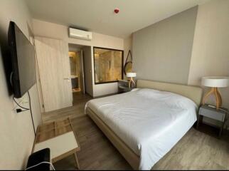 Modern bedroom with double bed, wall-mounted TV, air conditioning, and ensuite bathroom