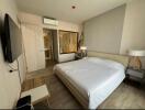 Modern bedroom with double bed, wall-mounted TV, air conditioning, and ensuite bathroom