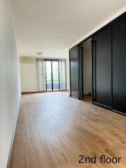 Spacious living room with large glass doors and wooden flooring