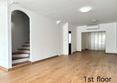 Spacious main living area with staircase and wooden flooring