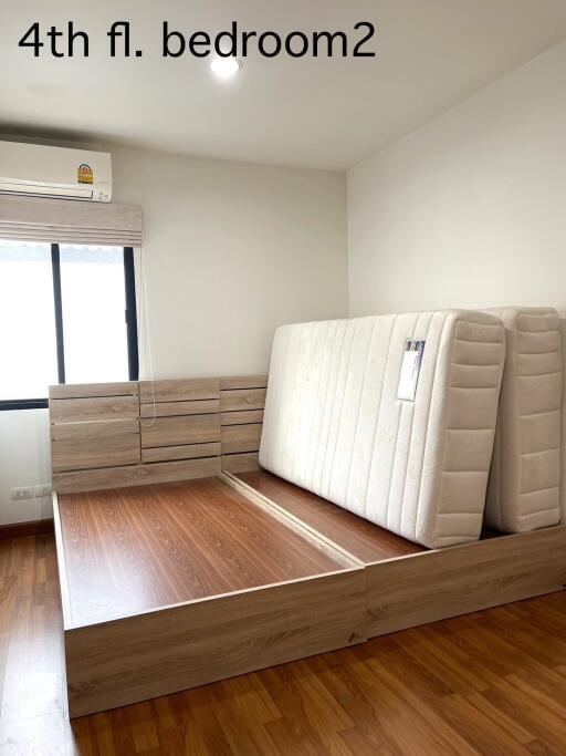 Bedroom on 4th floor with bed frame and stacked mattresses