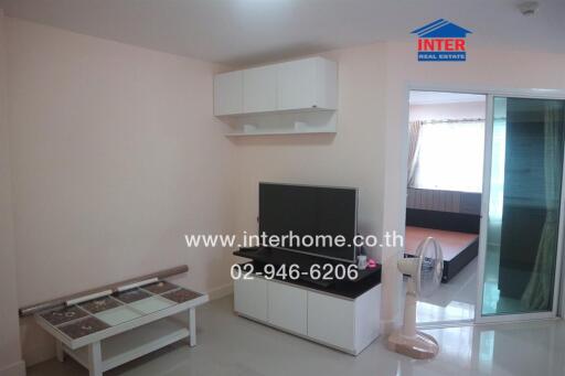 Living room with television, table, and sliding glass door