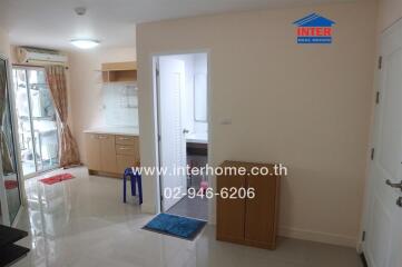 Interior view of a studio apartment with a kitchen area, bathroom door, and air-conditioning unit.