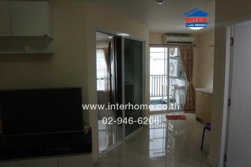 Living space in the apartment with a view towards the balcony and laundry area