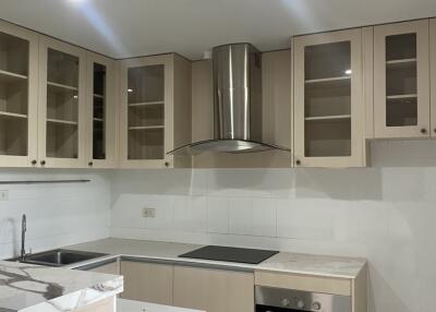 Modern kitchen with beige cabinets and stainless steel appliances