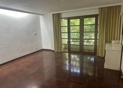 Spacious living room with hardwood flooring and large windows