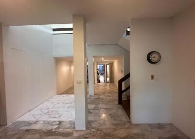 Interior view of a hallway with marble flooring and a staircase