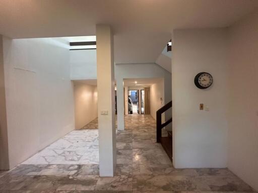 Interior view of a hallway with marble flooring and a staircase