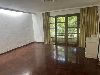 Spacious living room with wooden flooring and large windows