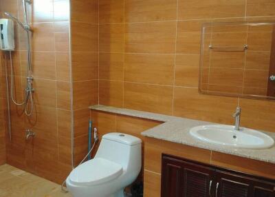 Modern bathroom with large tiles and equipped with a shower, toilet, and sink
