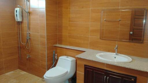 Modern bathroom with large tiles and equipped with a shower, toilet, and sink