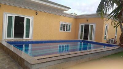 Swimming pool in the backyard of a house with spacious patio area