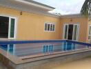 Swimming pool in the backyard of a house with spacious patio area