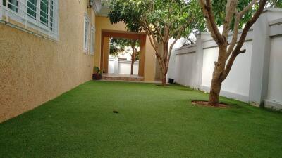 Well-maintained garden with artificial turf and trees