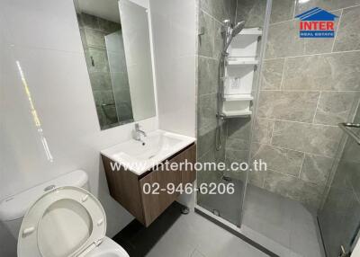 Modern bathroom with glass-enclosed shower, wall-mounted sink with mirror, and toilet