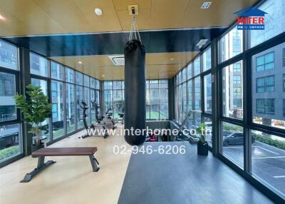 Spacious fitness center with exercise equipment, large windows, and a punching bag