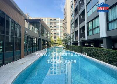 Outdoor swimming pool adjacent to a modern multi-story residential building