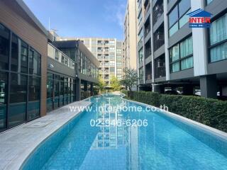 Outdoor swimming pool adjacent to a modern multi-story residential building