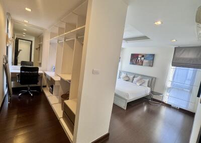 A spacious bedroom with a connected office space and ample storage