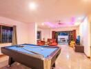 Spacious living area with pool table and seating arrangement