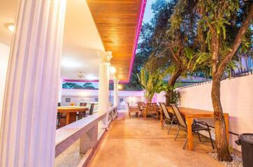 Elegant outdoor dining space with columns and ceiling lights