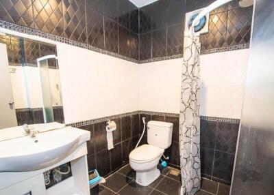 Bathroom with shower curtain, toilet, and sink